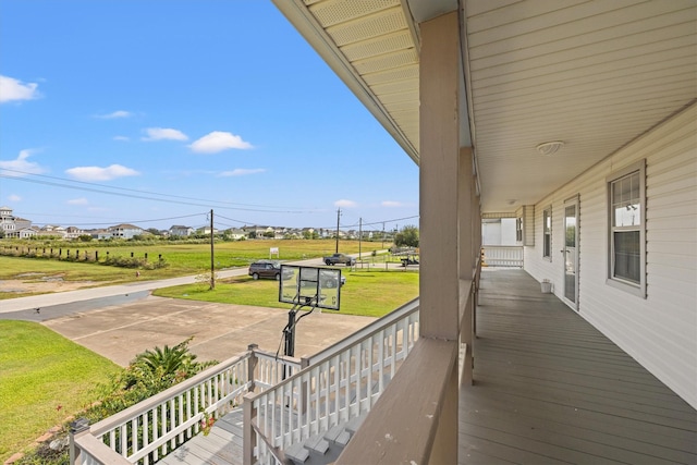 wooden deck featuring a porch and a lawn