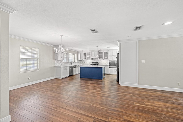 unfurnished living room with a sink, crown molding, visible vents, and dark wood-type flooring