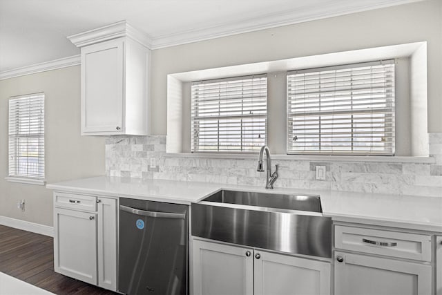 kitchen with a sink, light countertops, stainless steel dishwasher, decorative backsplash, and crown molding