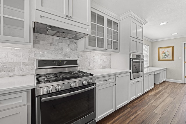 kitchen featuring dark wood-style floors, stainless steel appliances, light countertops, decorative backsplash, and glass insert cabinets