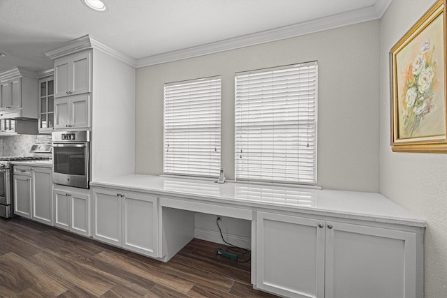 interior space featuring dark wood-style flooring, crown molding, and built in desk