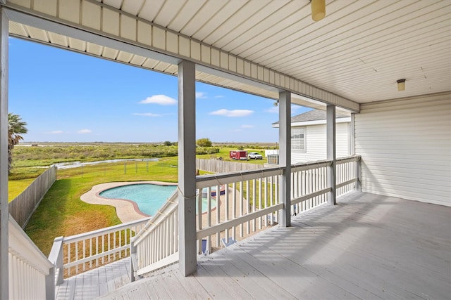 wooden terrace featuring a fenced in pool, a fenced backyard, and a lawn