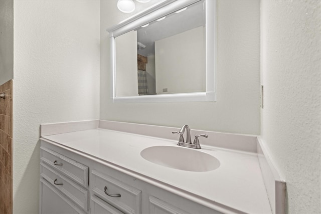 bathroom featuring a textured wall and vanity