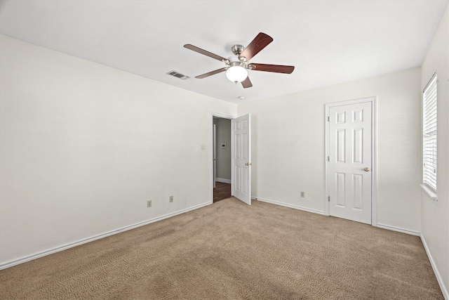 unfurnished bedroom featuring carpet, visible vents, ceiling fan, and baseboards