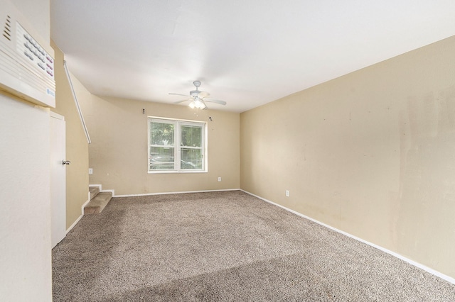 carpeted empty room with stairs, baseboards, and a ceiling fan