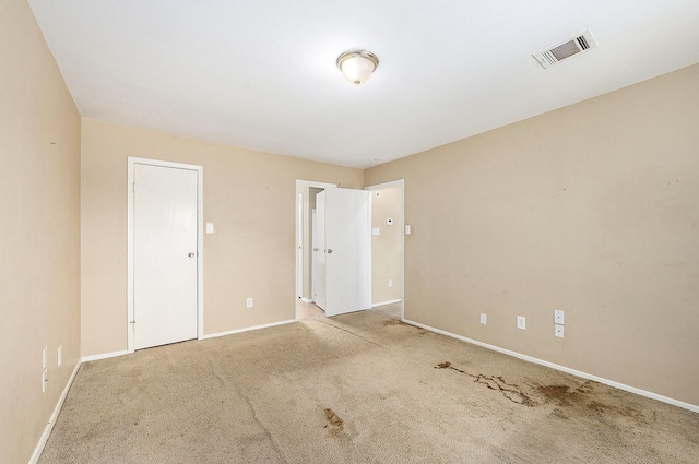 carpeted empty room featuring visible vents and baseboards