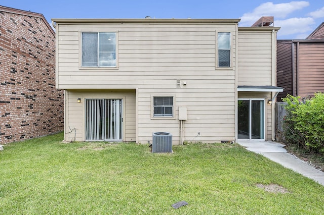 back of house featuring central AC and a yard