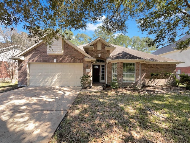 view of front facade with an attached garage, a shingled roof, concrete driveway, and brick siding