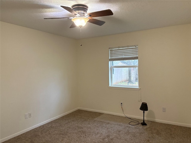 carpeted empty room with baseboards and a ceiling fan