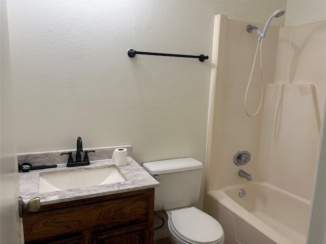 full bathroom featuring tub / shower combination, toilet, vanity, and a textured wall