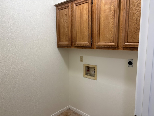 clothes washing area with cabinet space, electric dryer hookup, hookup for a washing machine, and baseboards