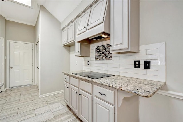 kitchen with baseboards, decorative backsplash, custom range hood, wood tiled floor, and black electric cooktop