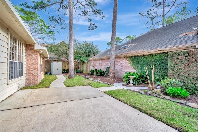 view of yard with an outbuilding, a patio area, and fence