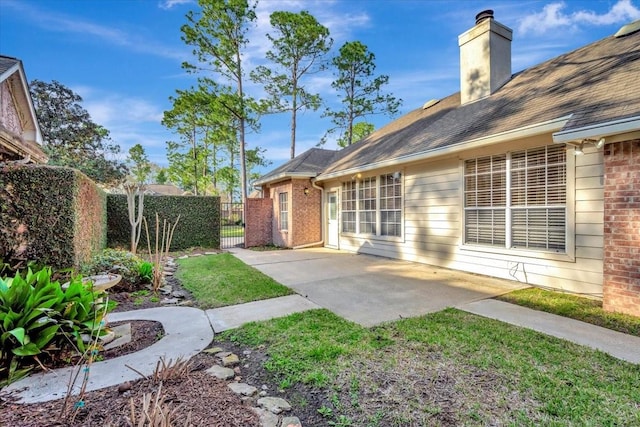 view of yard with a patio, fence, and a gate