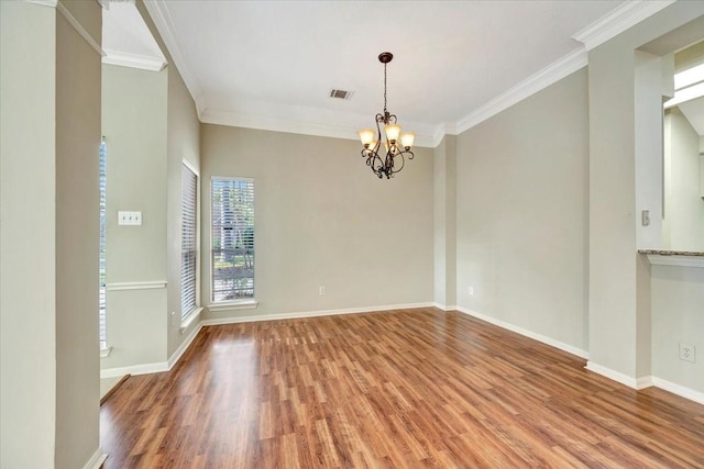 unfurnished room featuring crown molding, wood finished floors, visible vents, and an inviting chandelier