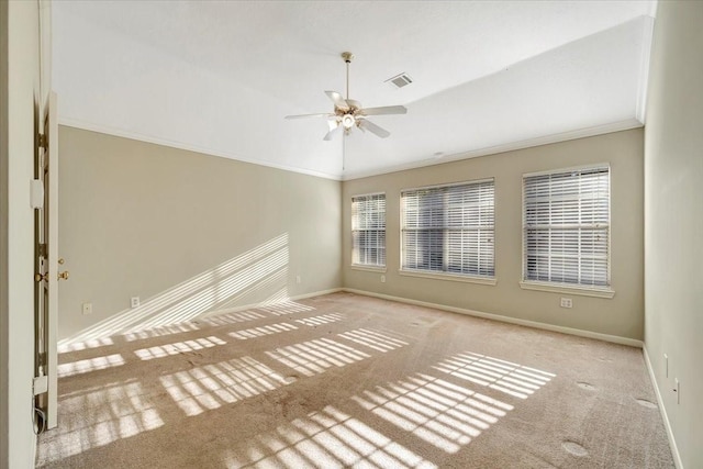 spare room featuring visible vents, ornamental molding, carpet flooring, vaulted ceiling, and baseboards