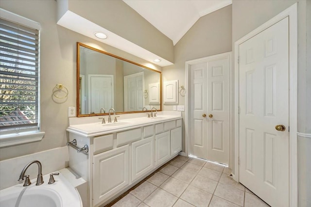 bathroom featuring double vanity, vaulted ceiling, a sink, and tile patterned floors