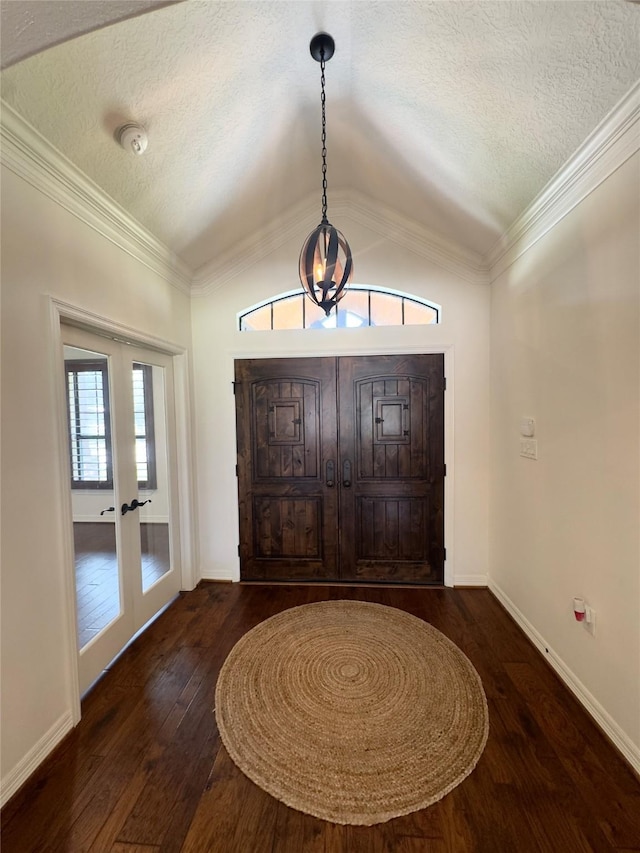 foyer entrance with vaulted ceiling, french doors, a textured ceiling, and hardwood / wood-style floors