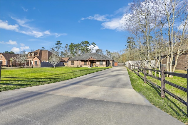 view of front facade with a front yard, concrete driveway, and fence