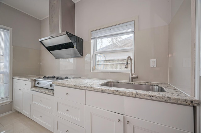 kitchen featuring plenty of natural light, stovetop, a sink, and wall chimney exhaust hood