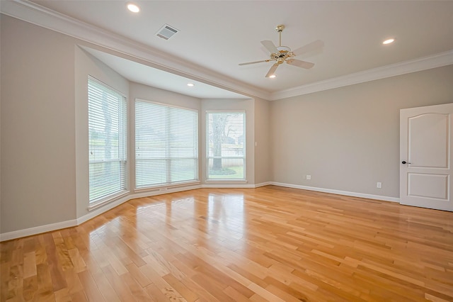 unfurnished room with crown molding, plenty of natural light, and light wood finished floors