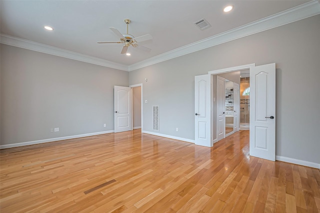 spare room with light wood-style flooring, visible vents, baseboards, a ceiling fan, and ornamental molding