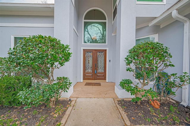 entrance to property featuring french doors and stucco siding