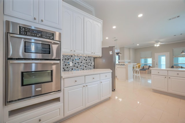 kitchen with tasteful backsplash, visible vents, double oven, open floor plan, and white cabinetry