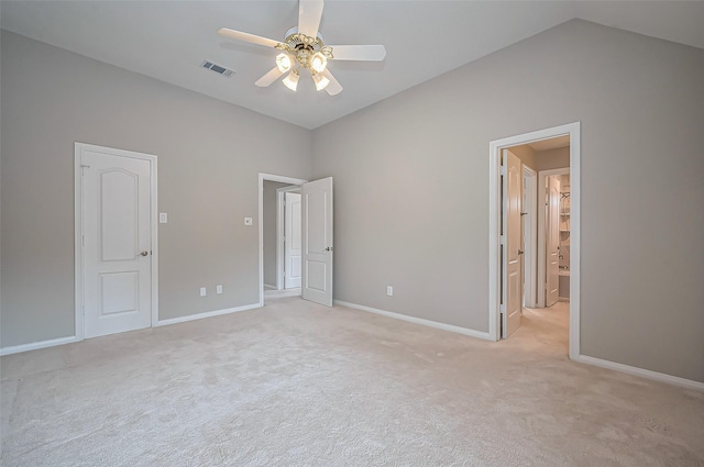 unfurnished bedroom with light colored carpet, visible vents, vaulted ceiling, and baseboards