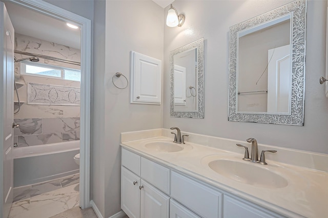 bathroom featuring double vanity, marble finish floor, a sink, and shower / bathing tub combination