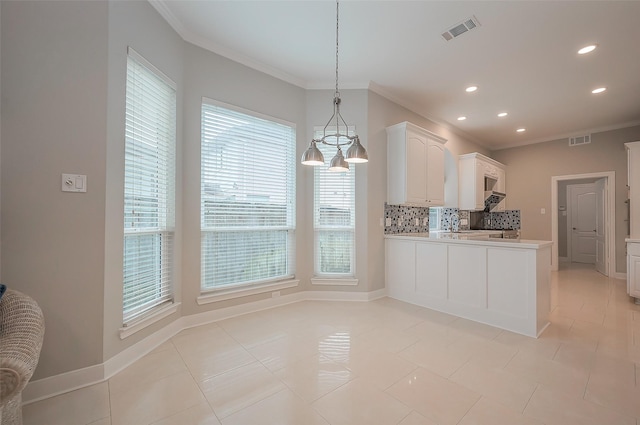 kitchen featuring light countertops, ornamental molding, visible vents, and decorative backsplash