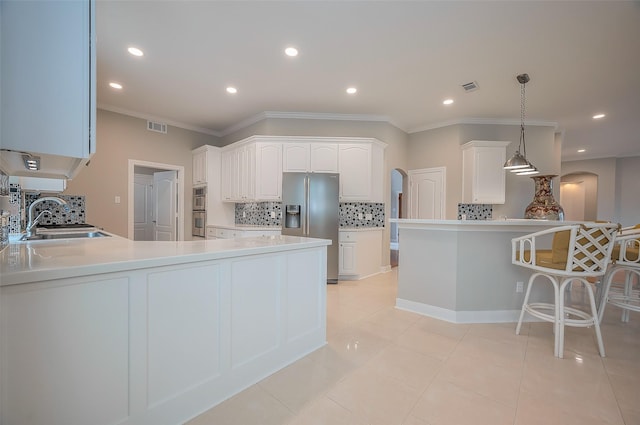 kitchen featuring visible vents, white cabinets, appliances with stainless steel finishes, a peninsula, and a sink