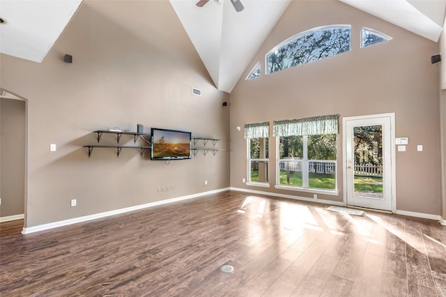 unfurnished living room featuring a ceiling fan, a wealth of natural light, visible vents, and wood finished floors