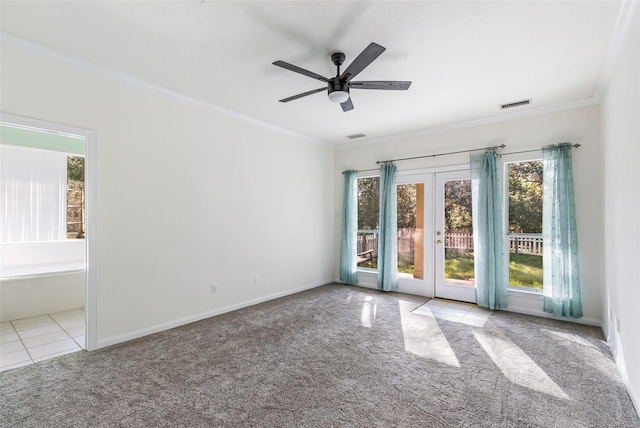 carpeted empty room with french doors, visible vents, ornamental molding, ceiling fan, and baseboards