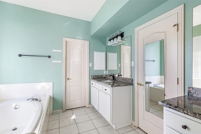 bathroom with tile patterned flooring, a garden tub, and vanity