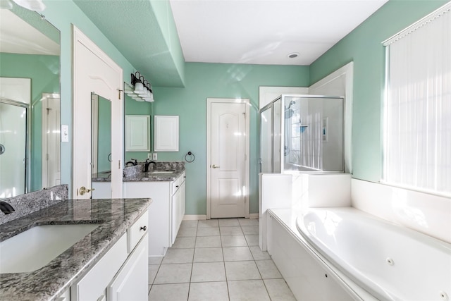 bathroom with two vanities, a sink, a shower stall, a tub with jets, and tile patterned floors