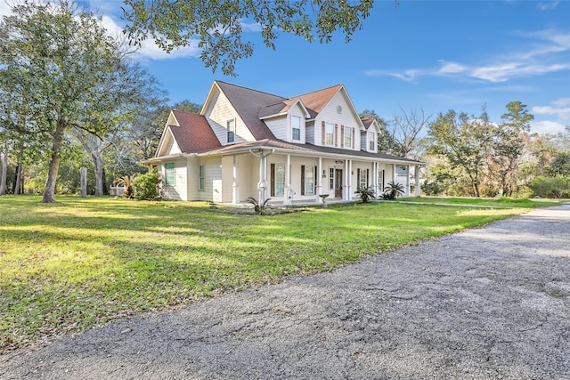 view of side of property with covered porch and a lawn