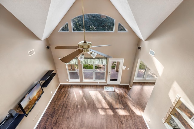 unfurnished living room with ceiling fan, visible vents, and wood finished floors