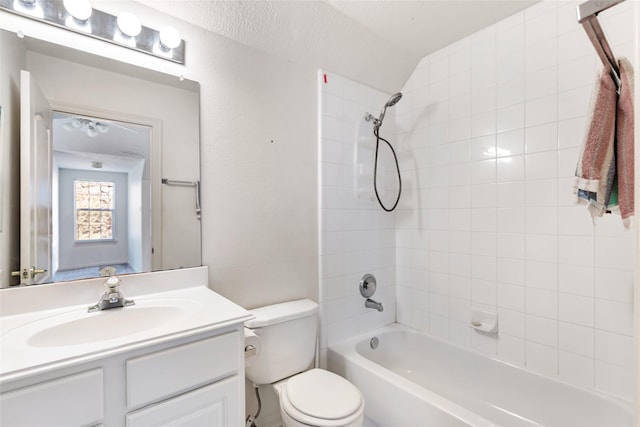 full bathroom featuring toilet, a textured wall, bathing tub / shower combination, and vanity