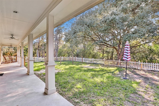 view of yard with ceiling fan and fence