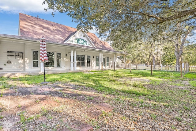 rear view of property with a yard and fence