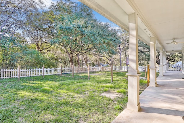 view of yard with ceiling fan, a porch, and fence private yard