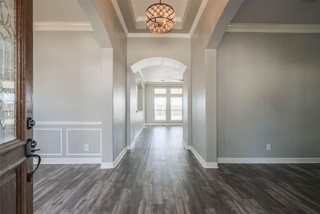 entryway with dark wood-type flooring, arched walkways, a chandelier, and crown molding