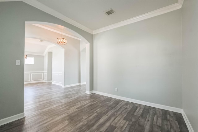 unfurnished room with dark wood-style floors, visible vents, ornamental molding, and arched walkways