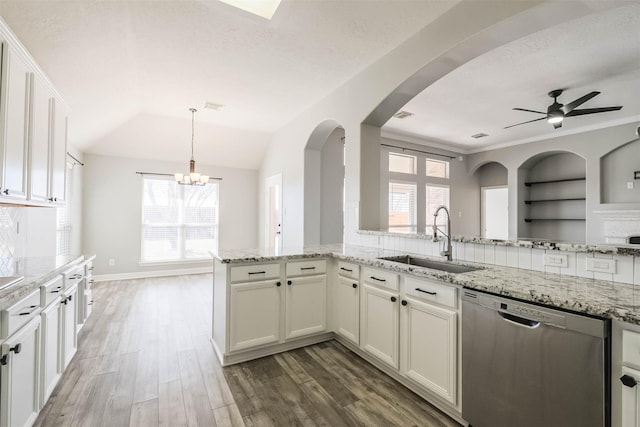 kitchen with light stone counters, light wood finished floors, stainless steel dishwasher, white cabinetry, and a sink