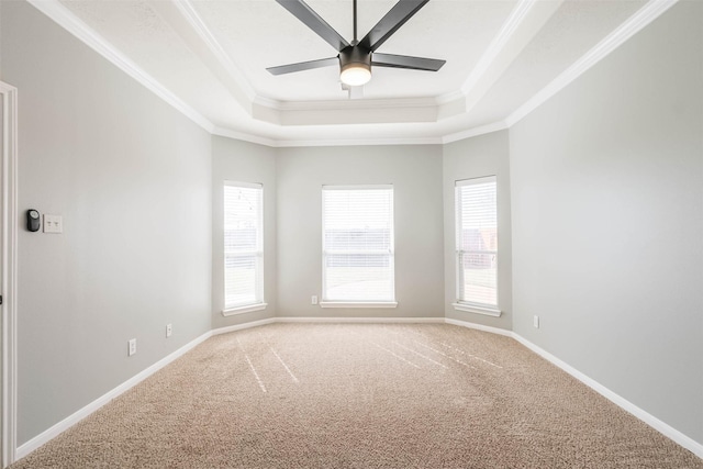 carpeted empty room featuring baseboards, a tray ceiling, ceiling fan, and crown molding