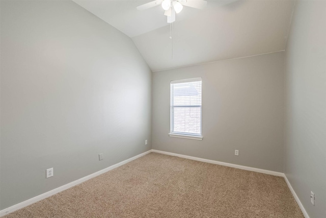 carpeted spare room with lofted ceiling, ceiling fan, and baseboards