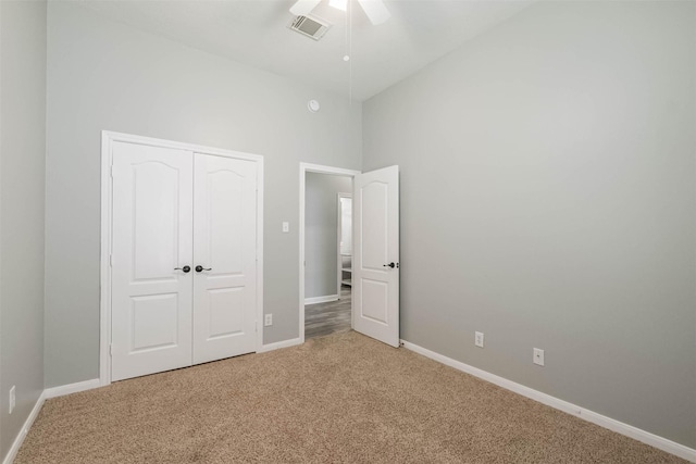 unfurnished bedroom featuring a closet, light colored carpet, visible vents, and baseboards