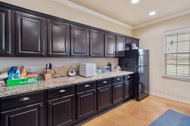 kitchen featuring light stone counters, recessed lighting, baseboards, freestanding refrigerator, and crown molding