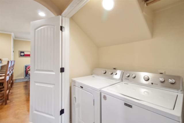 laundry room with laundry area, separate washer and dryer, light wood-type flooring, and crown molding